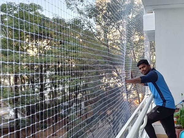 Technician installing a balcony safety net