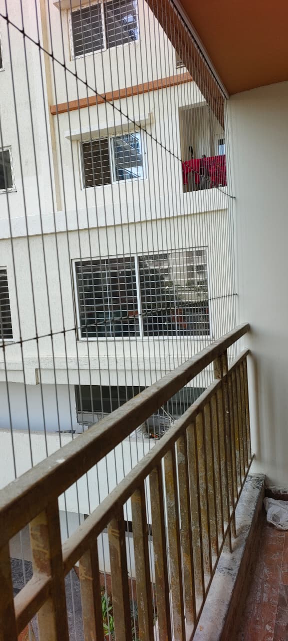 Invisible grill fitted on an older apartment balcony railing