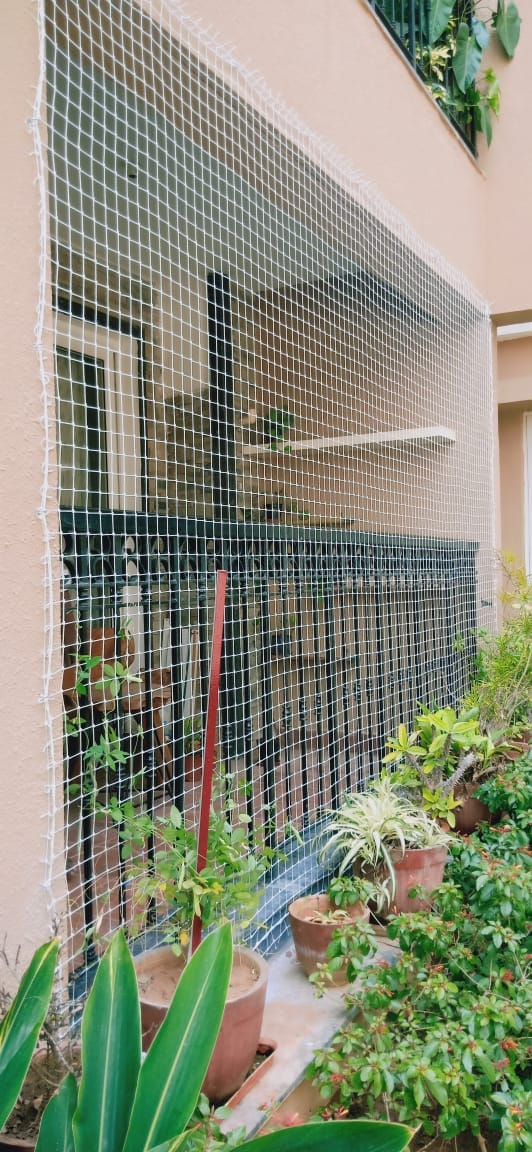 Full-height balcony safety net with a clear city view