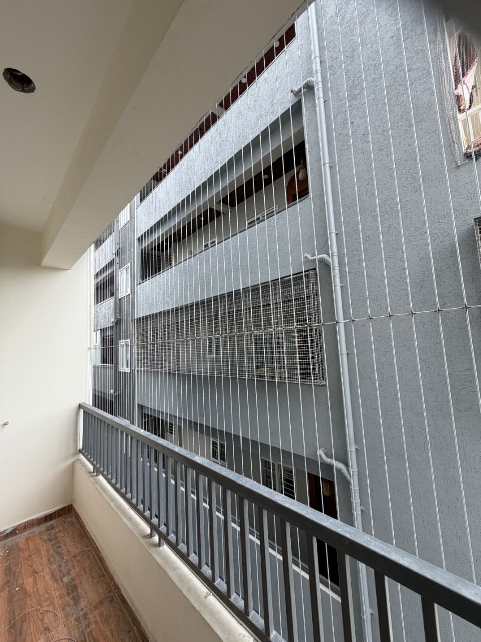 Invisible grill along a corridor balcony of an apartment block