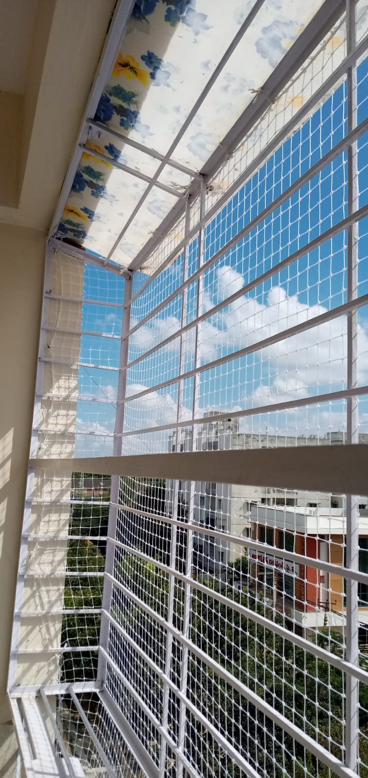 Balcony safety net fitted along an apartment corridor railing