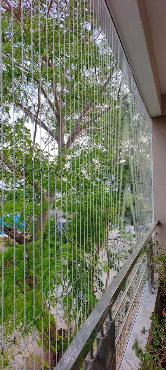 Invisible grill on a balcony overlooking trees
