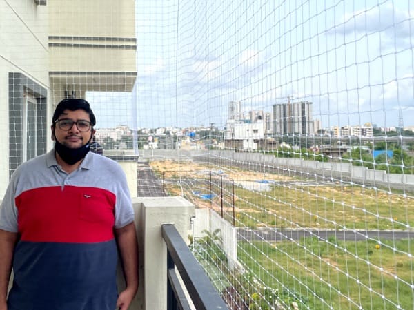 Customer beside a completed balcony safety net installation
